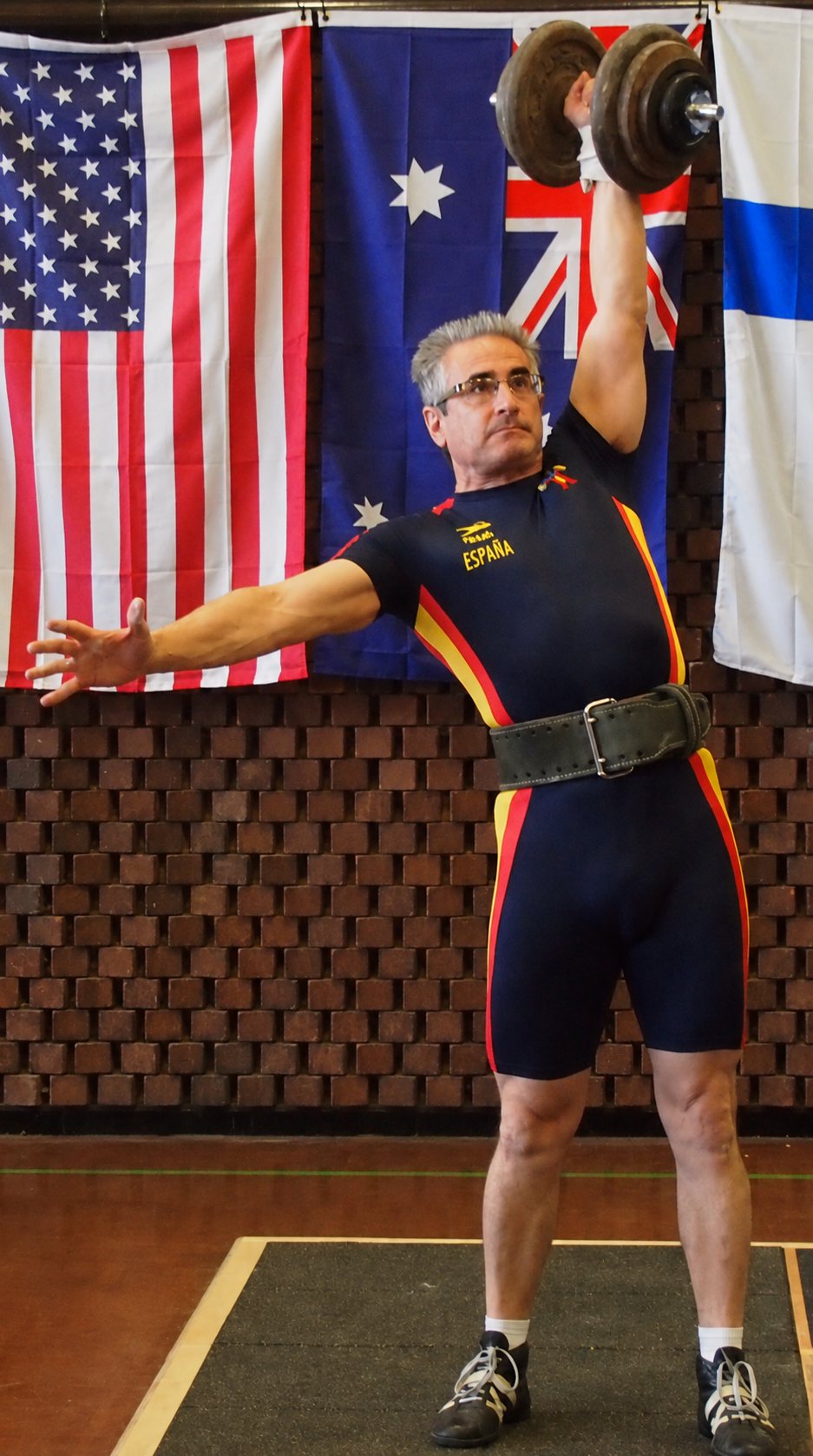 Lucio Doncel ejecutando una arrancada de mancuerna a una mano en competición, con el maillot de España